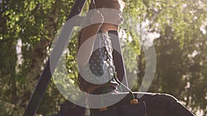 Happy child swinging on a swing and enjoying a beautiful summer day. concept of joy and happy childhood