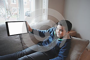 Happy Child with tablet computer. Portrait Kid Holding And Showing Digital Tablet With Empty Screen  Mockup, Young boy sitting on