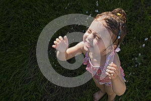 Happy child taking shower outdoors. Summer vacation and healthy lifestyle concept