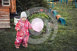 Happy child toddler playing with balloon outdoors on green lawn grass on backyard playground