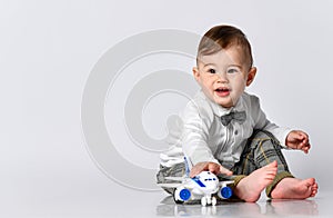 Happy child toddler playing with toy airplane and dreaming of becoming a pilot