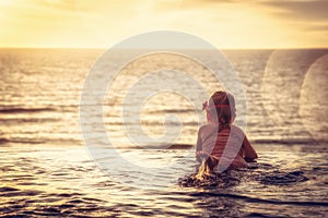 Happy child toddler swimming infinity swimming pool at sunset as travel lifestyle