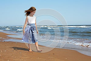 Happy child walks along the coastline ocean