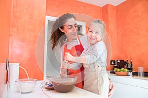 Happy child whipping chocolate with mother