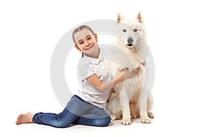 Happy child with white dog. Portrait girl with pet. Smilyng Samoyed Laika dog.