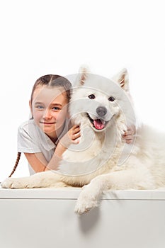 Happy child with white dog. Portrait girl with pet. Smilyng Samoyed Laika dog.