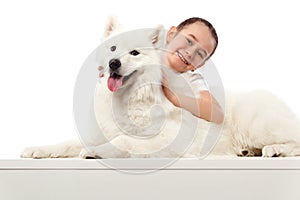 Happy child with white dog. Portrait girl with pet. Smilyng Samoyed Laika dog.