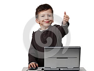 Happy child working on laptop with thumbs up