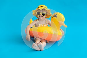 Happy child with yellow rubber duck against blue background