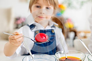 Happy childen, siblings, coloring eggs for Easter at home, sunny room