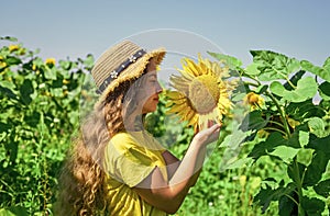 happy childhood. beautiful girl wear straw summer hat in field. pretty kid with flower. beauty of summer nature. little