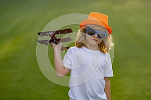 Happy childhood. Child boy toddler playing with toy airplane wings and dreaming future. The concept of child kindness