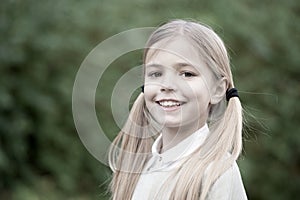 Happy childhood and childcare. Child with smile on cute face outdoor. Little girl with long blond hair. Beauty kid with