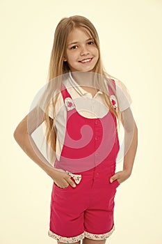Happy childhood and childcare. Small girl smile in pink jumpsuit isolated on white. Child smiling with long blond hair