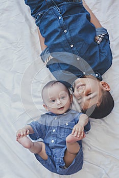 Happy childhood concept. Happy brothers portrait. 6 years boy and 6 months old baby boy having fun. Two little kids smiling to the