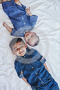 Happy childhood concept. Happy brothers portrait. 6 years boy and 6 months old baby boy having fun. Two little kids smiling to the