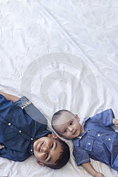 Happy childhood concept. Happy brothers portrait. 6 years boy and 6 months old baby boy having fun. Two little kids smiling to the