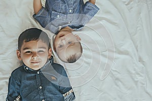 Happy childhood concept. Happy brothers portrait. 6 years boy and 6 months old baby boy having fun. Two little kids smiling to the