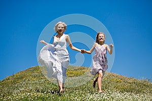 Happy childhood concept, mother and daughter holding hands, running.