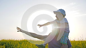 Happy childhood, field walk of dad and son in sunny weather, daddy with little boy go by field and point hand to horizon