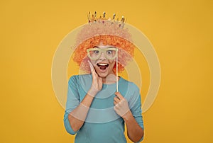 happy childhood. girls birthday party. happy funny kid in curly wig and crown.