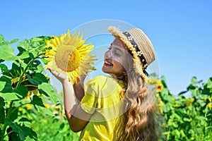 happy childhood. kid wear straw summer hat. child in field of yellow flowers. teen girl in sunflower field. concept of