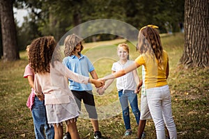 Happy childhood.  Large group of school kids having fun in nature