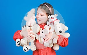 Happy childhood. Little girl play with soft toy teddy bear. Lot of toys in her hands. Childhood concept. Collecting toys