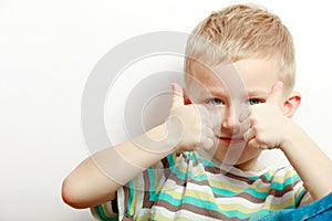 Happy childhood. Smiling blond boy child kid showing thumb up