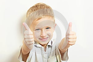 Happy childhood. Smiling blond boy child kid showing thumb up