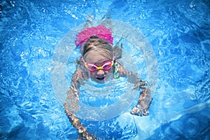Happy childhood. Young child girl swimming in pool and having fun leisure activity