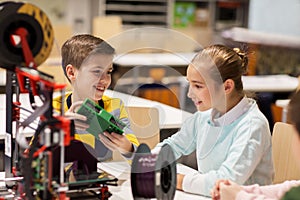 Happy children with 3d printer at robotics school