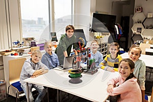 Happy children with 3d printer at robotics school