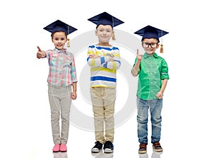 Happy children in bachelor hats and eyeglasses