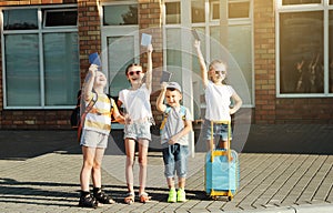 Happy children with backpacks and passports on bus station are ready to travel