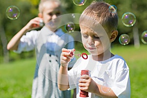 Happy children blow soap bubbles