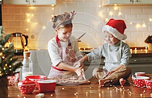 Happy children boy and girl bake christmas cookies