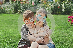 Happy children, boy and girl with face paint in park