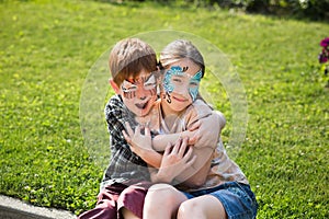 Happy children, boy and girl with face paint in park