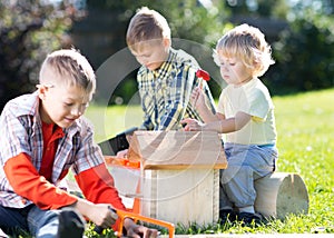 Happy children boys brothers tinkering outdoors