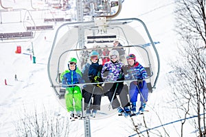 Happy children in bright ski outfit on chairlift