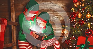 happy children brother and sister elf, helper of Santa with Christmas magic gifts