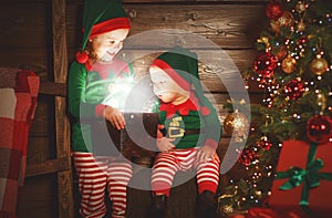 happy children brother and sister elf, helper of Santa with Christmas magic gifts