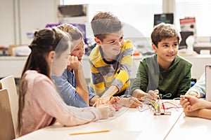 Happy children building robots at robotics school