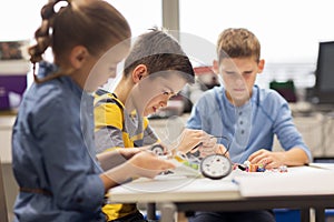 Happy children building robots at robotics school