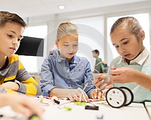 Happy children building robots at robotics school