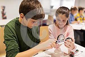 Happy children building robots at robotics school