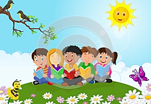 Happy children cartoon sitting on the grass while reading books photo