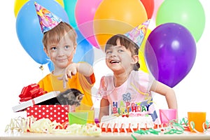 Happy children celebrating birthday party with opening gift box