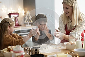 Children clasping using flour while baking cookies photo